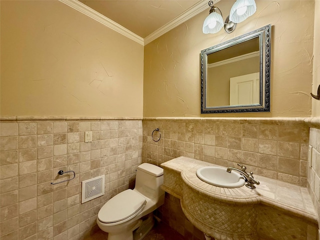 bathroom with toilet, ornamental molding, and tile walls