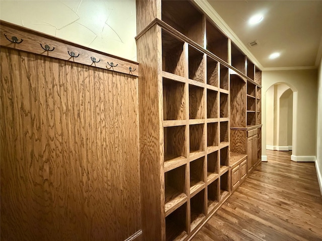 wine cellar featuring dark hardwood / wood-style flooring and ornamental molding