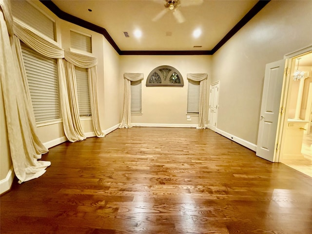 spare room featuring crown molding, hardwood / wood-style floors, and a notable chandelier