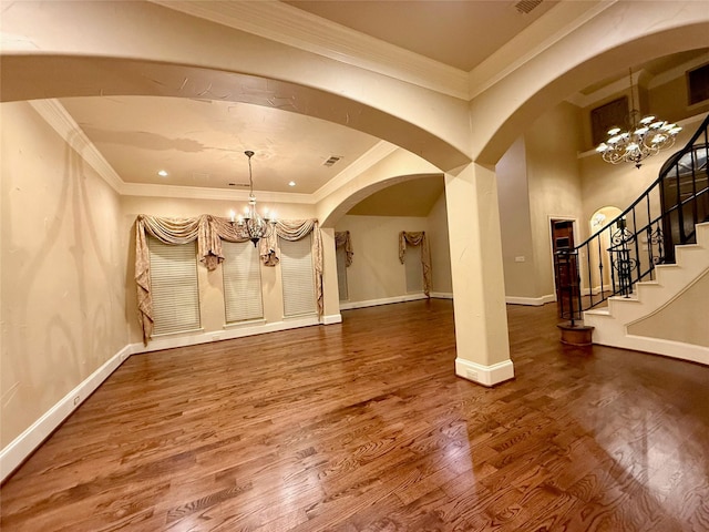 unfurnished dining area featuring hardwood / wood-style flooring, ornamental molding, and a notable chandelier