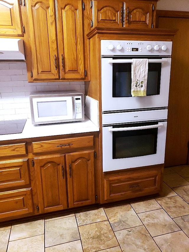 kitchen featuring backsplash, white appliances, and light tile patterned floors