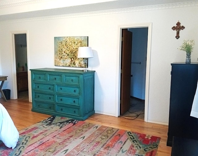 bedroom with a walk in closet, crown molding, and ensuite bath