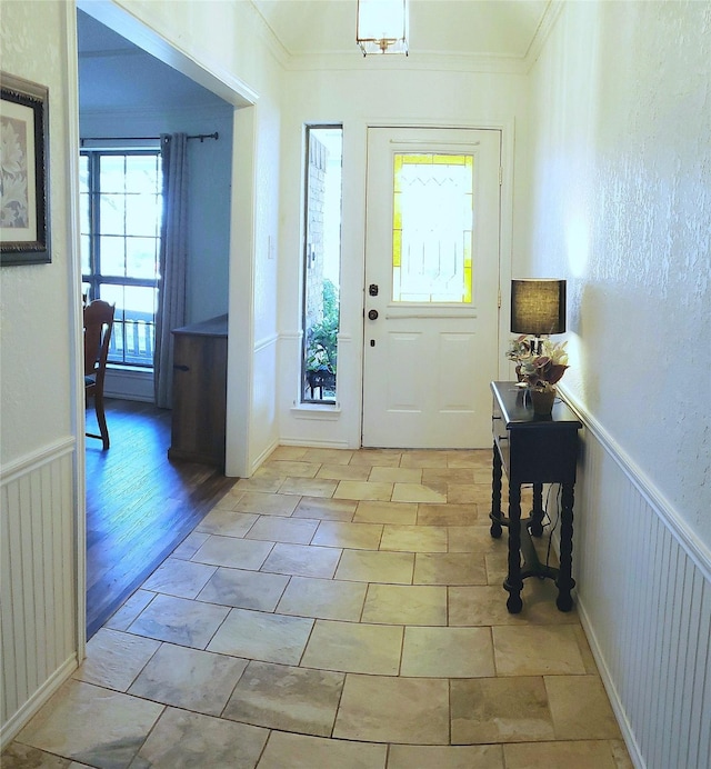 entrance foyer with light tile patterned floors and crown molding