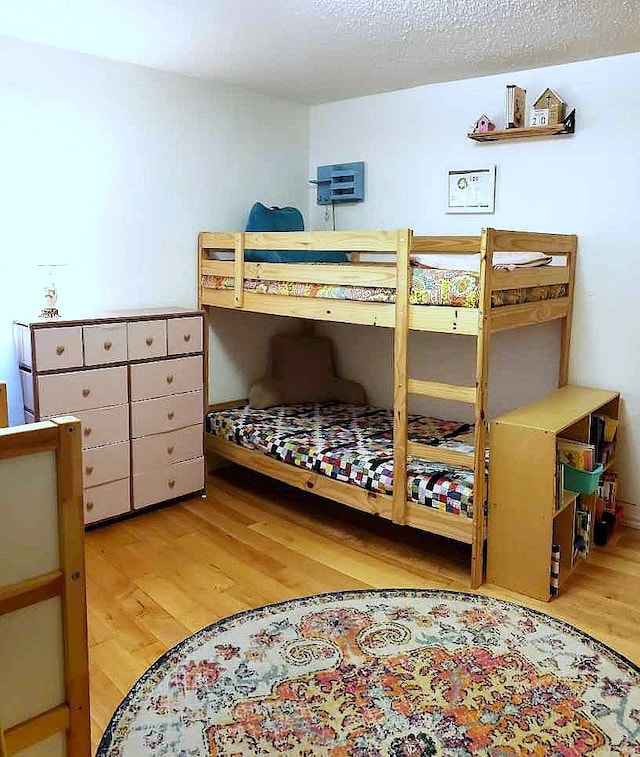 bedroom with light hardwood / wood-style floors and a textured ceiling