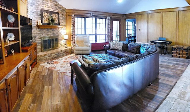 living room with a fireplace, hardwood / wood-style floors, wooden walls, and lofted ceiling