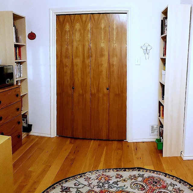 bedroom with light hardwood / wood-style floors and a closet