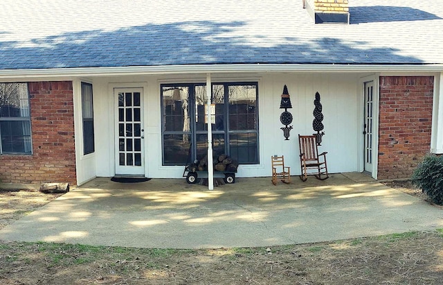 view of exterior entry with a patio area