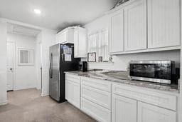 kitchen featuring stainless steel appliances and white cabinetry