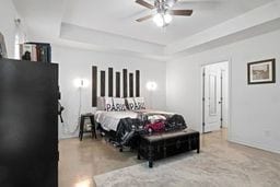 bedroom with a tray ceiling and ceiling fan