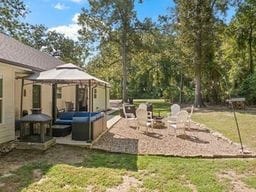 view of yard with a gazebo, a patio, and an outdoor living space with a fire pit