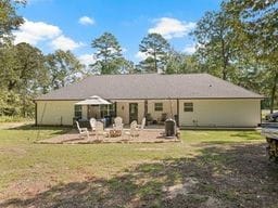 back of property with a lawn and a patio area