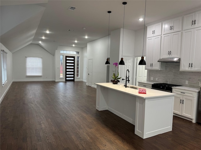 kitchen with lofted ceiling, white cabinetry, black gas stove, pendant lighting, and a kitchen island with sink