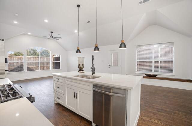 kitchen with pendant lighting, lofted ceiling, a kitchen island with sink, and stainless steel gas stove