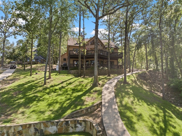 rear view of property featuring a yard and a deck