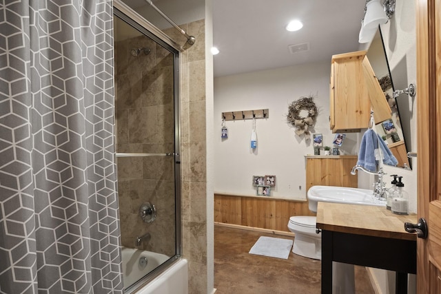 full bathroom with tiled shower / bath combo, concrete flooring, toilet, wooden walls, and vanity