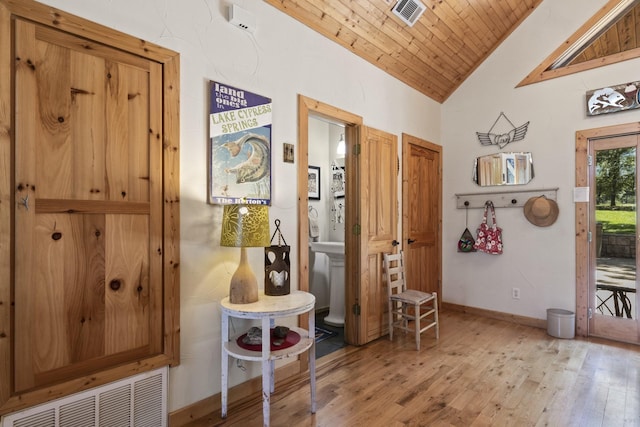 corridor with light hardwood / wood-style flooring, wood ceiling, and vaulted ceiling