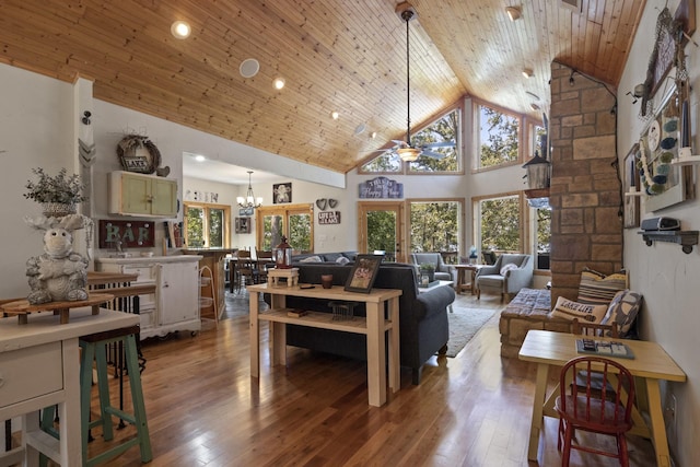 living room featuring hardwood / wood-style floors, ceiling fan with notable chandelier, high vaulted ceiling, and wood ceiling