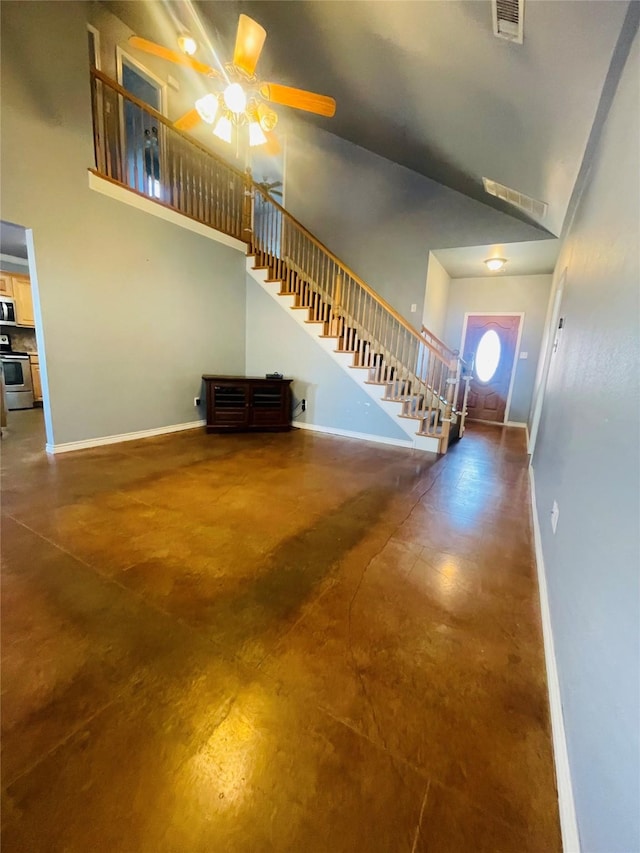 foyer with ceiling fan and concrete flooring