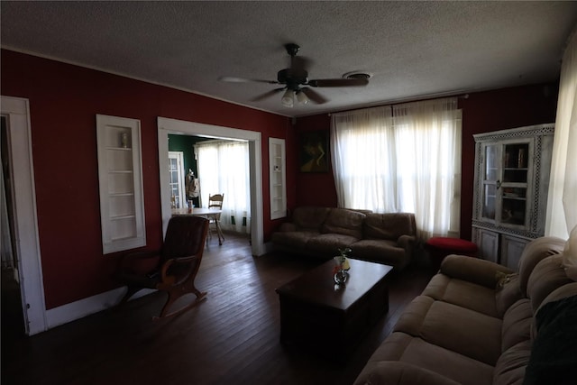 living room with ceiling fan, dark hardwood / wood-style floors, a textured ceiling, and a wealth of natural light