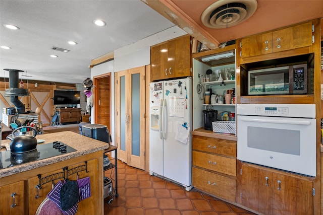 kitchen with white appliances and dark tile patterned floors