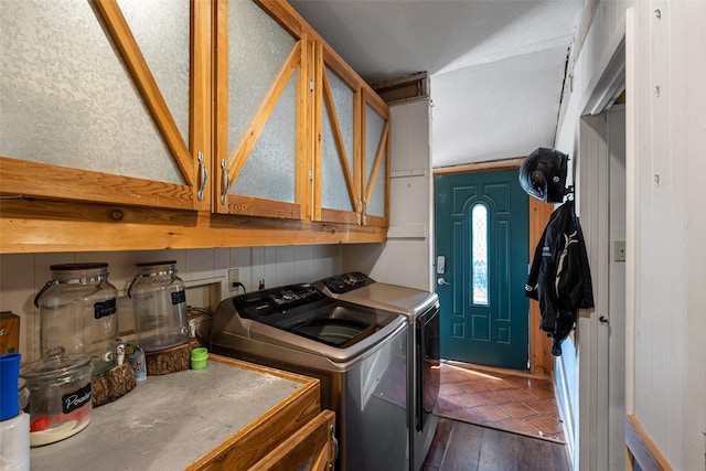 washroom featuring washer and dryer, wooden walls, dark wood-type flooring, and cabinets