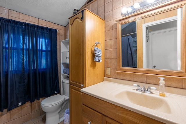 bathroom with vanity, a shower with shower curtain, toilet, a textured ceiling, and tile walls