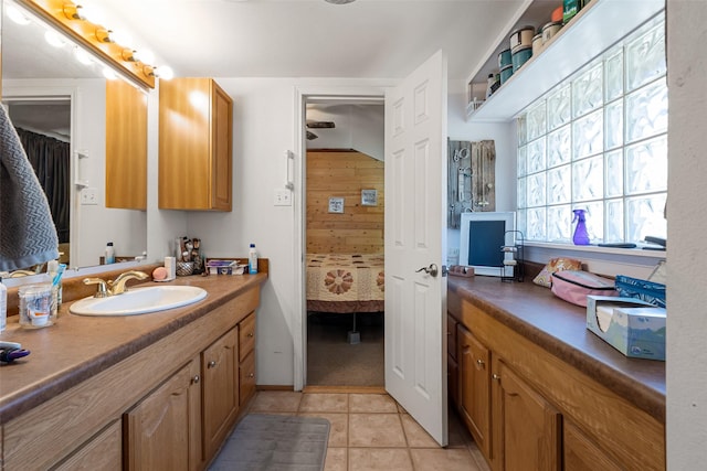 bathroom featuring vanity, tile patterned floors, and wooden walls