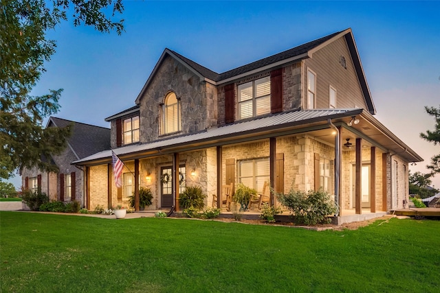 view of front of house featuring covered porch and a yard