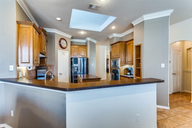 kitchen featuring kitchen peninsula, a skylight, and stainless steel appliances