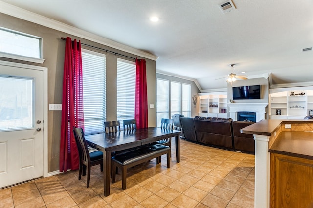 tiled dining space with ceiling fan, vaulted ceiling, and ornamental molding