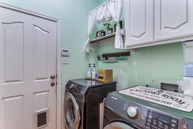 laundry room with washer and dryer and cabinets