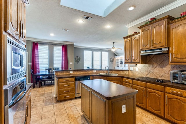 kitchen featuring a center island, sink, ornamental molding, appliances with stainless steel finishes, and kitchen peninsula