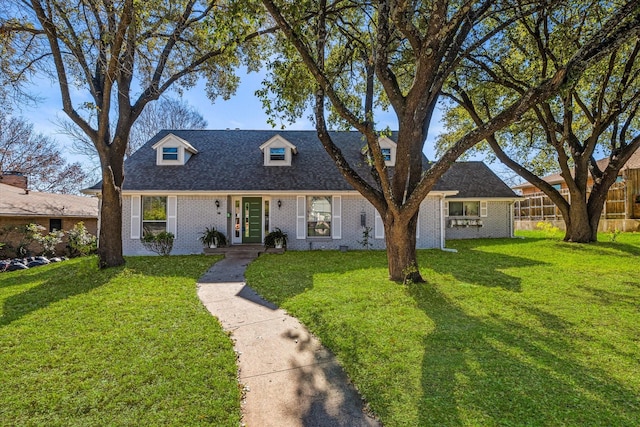 cape cod home featuring a front yard