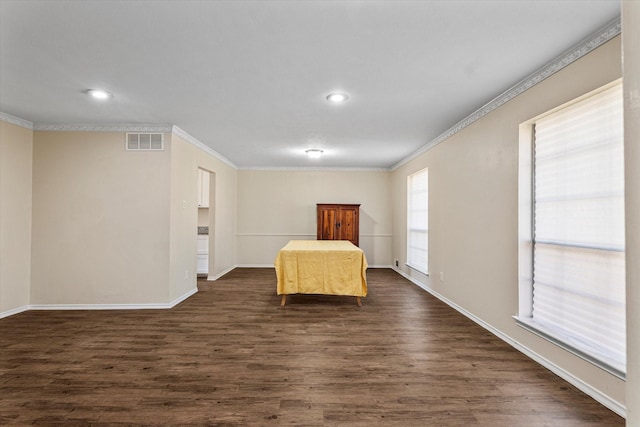 unfurnished bedroom with crown molding and dark wood-type flooring