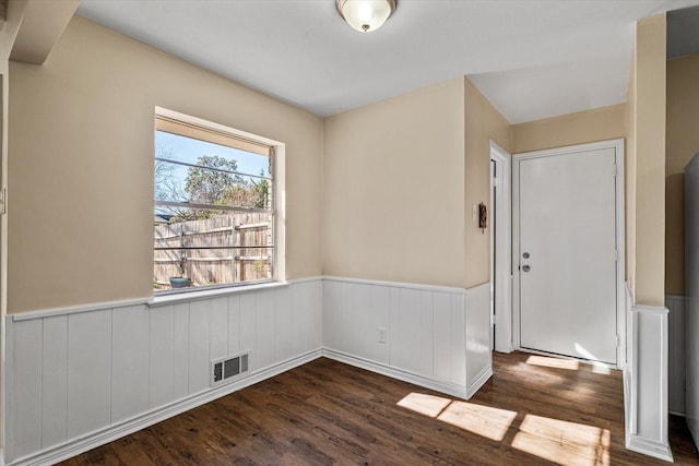 unfurnished room with dark wood-type flooring