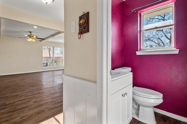 bathroom featuring vanity, ceiling fan, wood-type flooring, beamed ceiling, and toilet