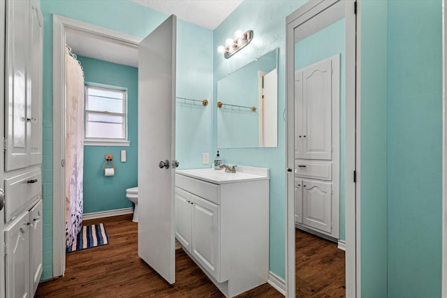 bathroom with wood-type flooring, vanity, and toilet