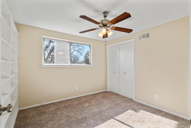 unfurnished bedroom with ceiling fan, a closet, and carpet floors