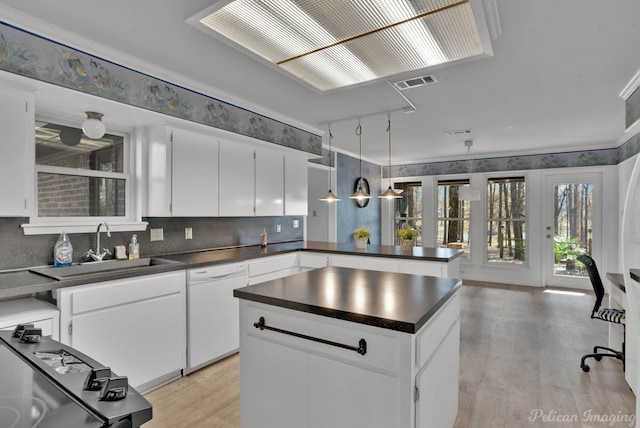 kitchen featuring dishwasher, decorative light fixtures, light hardwood / wood-style floors, white cabinetry, and sink