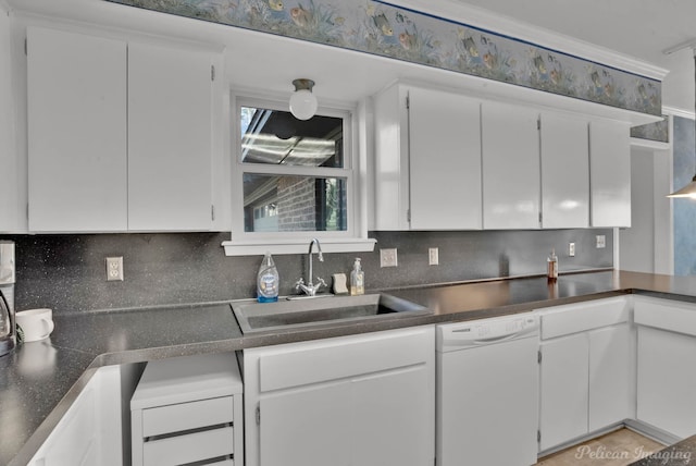 kitchen featuring sink, white dishwasher, white cabinets, and decorative backsplash