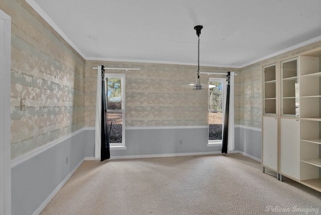 carpeted spare room featuring a wealth of natural light, a barn door, and crown molding