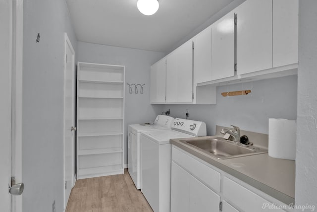 washroom with sink, cabinets, separate washer and dryer, and light hardwood / wood-style floors