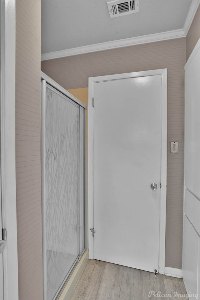 bathroom with ornamental molding and hardwood / wood-style floors