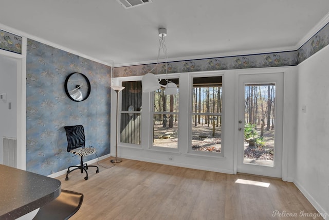 doorway to outside with hardwood / wood-style flooring and crown molding