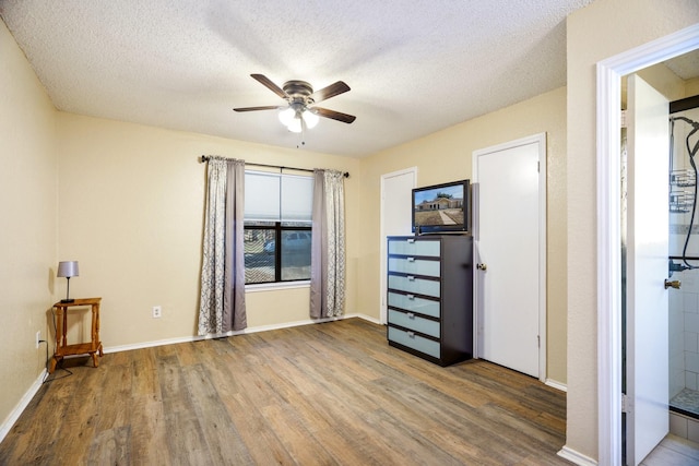 unfurnished bedroom with hardwood / wood-style flooring, a textured ceiling, and ceiling fan