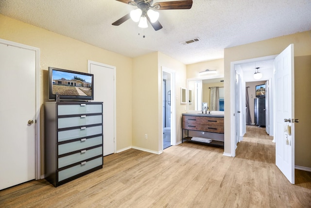 bedroom featuring sink, a textured ceiling, ceiling fan, and light hardwood / wood-style floors