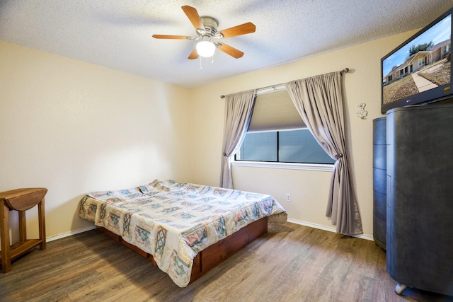 bedroom with a textured ceiling, ceiling fan, and dark hardwood / wood-style floors