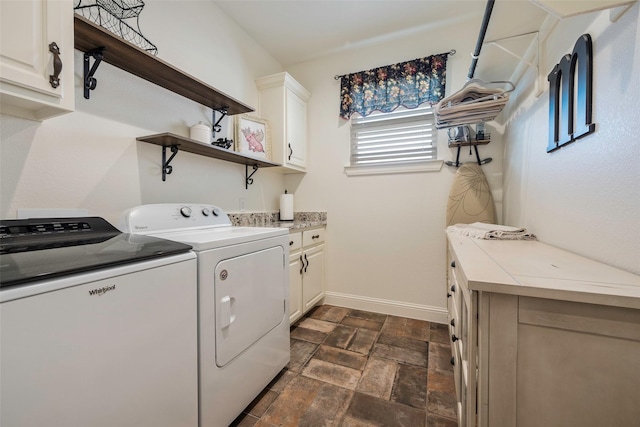 clothes washing area featuring cabinets and washer and clothes dryer