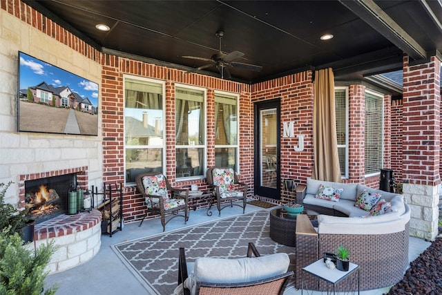 view of patio / terrace featuring an outdoor living space with a fireplace and ceiling fan