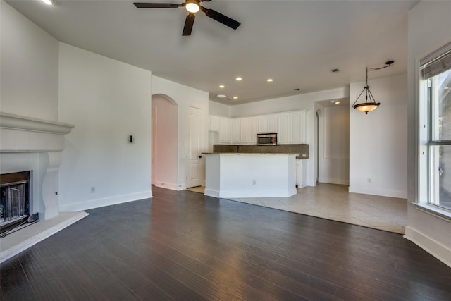 unfurnished living room featuring hardwood / wood-style flooring, plenty of natural light, and ceiling fan